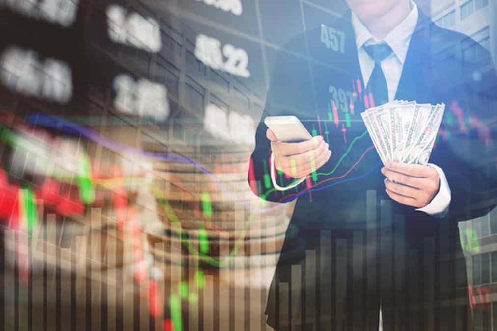 Businessman Holding money US dollar bills on digital stock market financial exchange information and