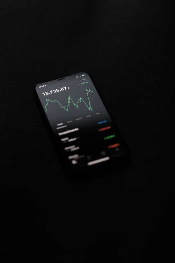 black background photo of cellphone with graphs - Image of Cryptocurrency Investing, "advanced crypt