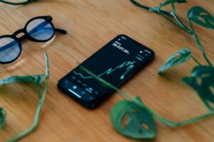 cell phone lays on a wooden table showing a chart - Image of Cryptocurrency Investing, "Fast crypto