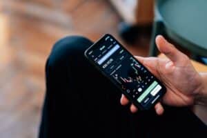 persons hand holding a phone showing a bitcoin chart - Image of Cryptocurrency, "cryptocurrency inve